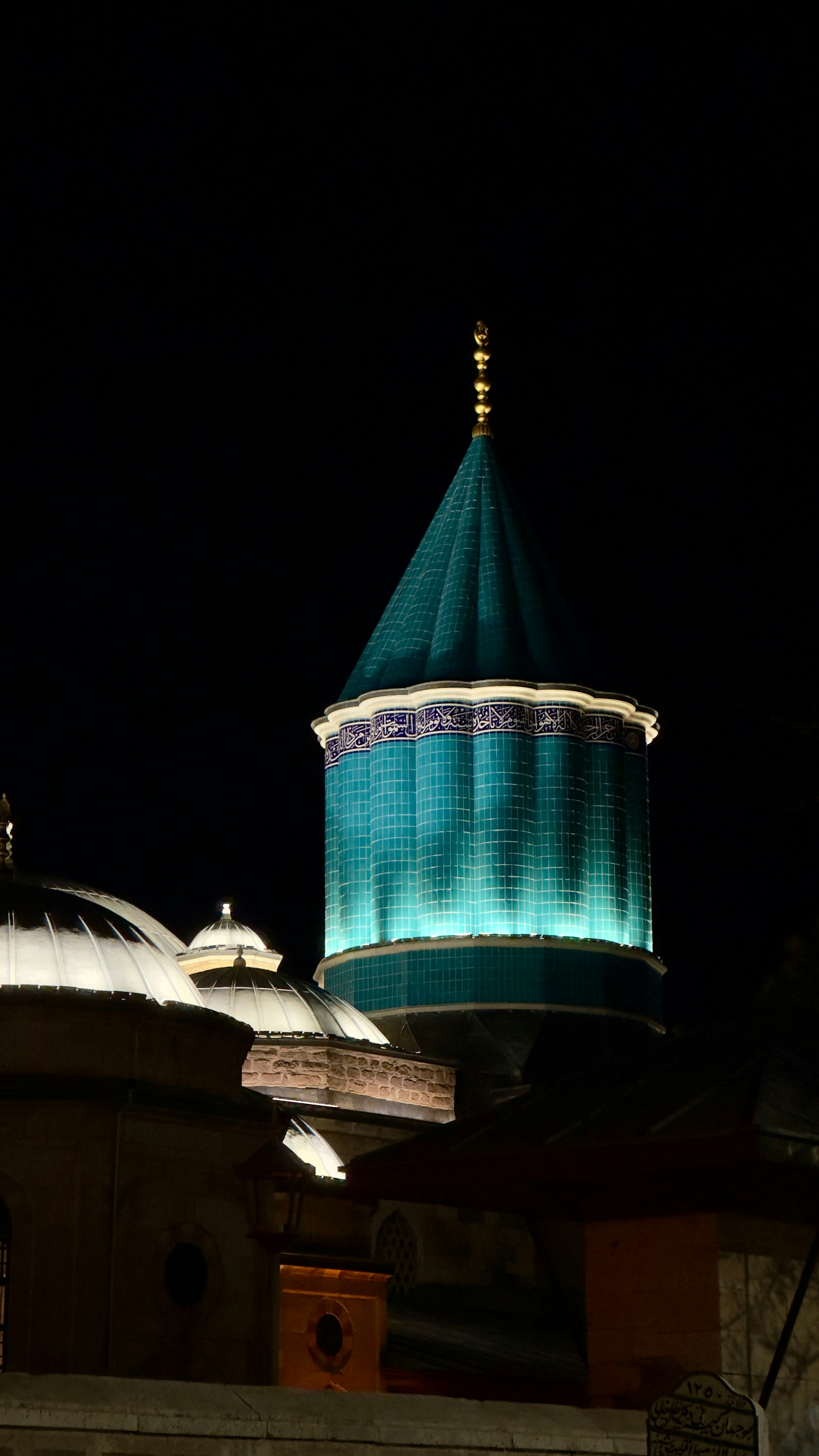 Mevlana Museum's iconic turquoise dome illuminated at night in Konya, Turkey