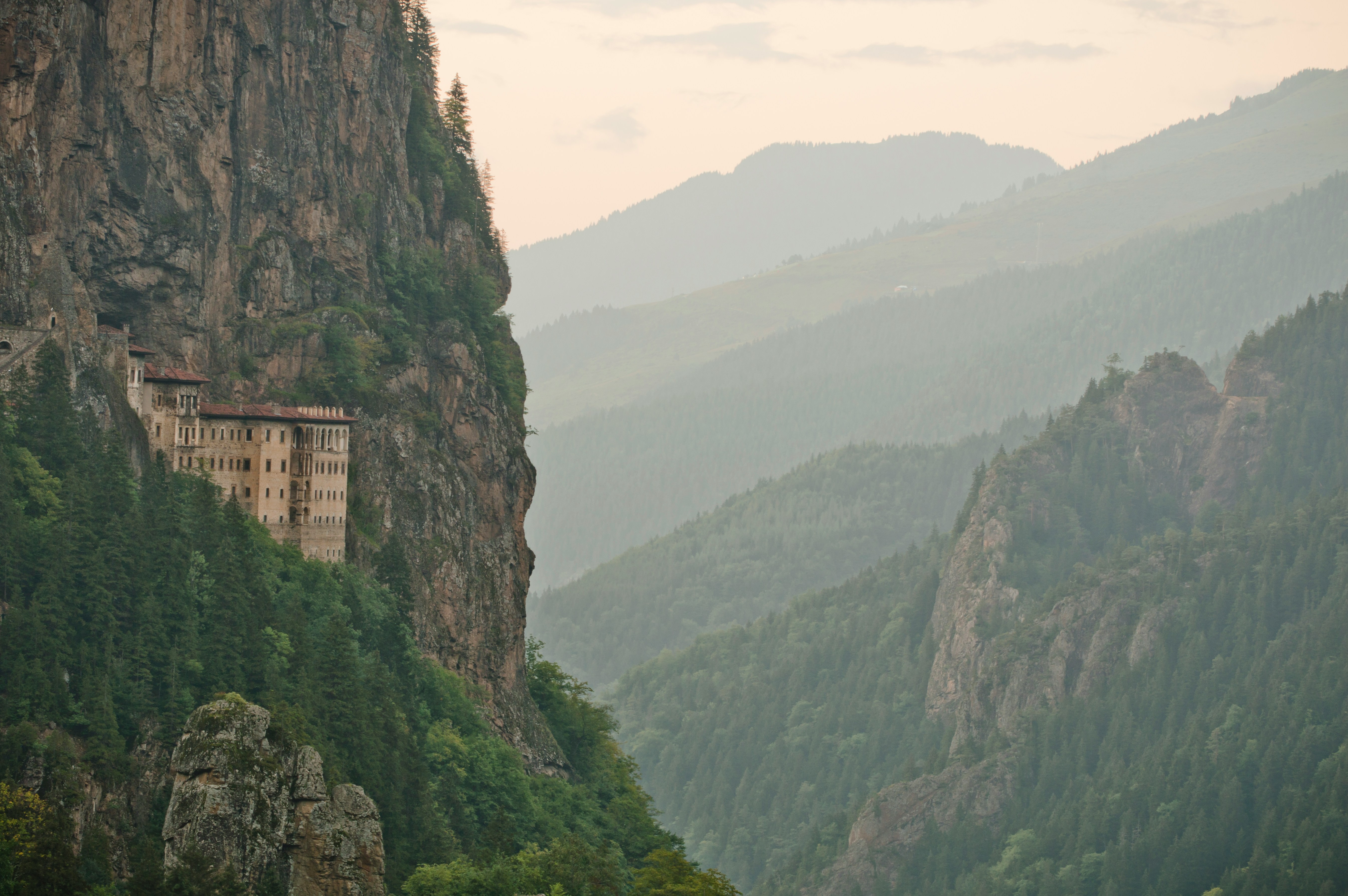 Sümela Monastery built into a vertical cliff face surrounded by forested mountains, Trabzon province, Turkey