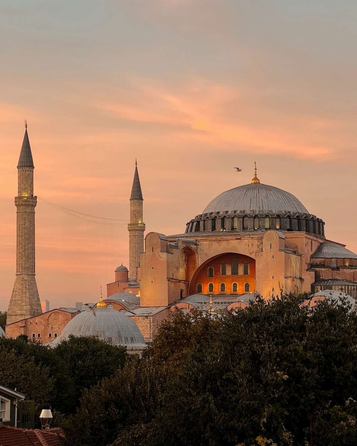 Hagia Sophia at sunset with minarets silhouetted against an orange sky, Istanbul, Turkey