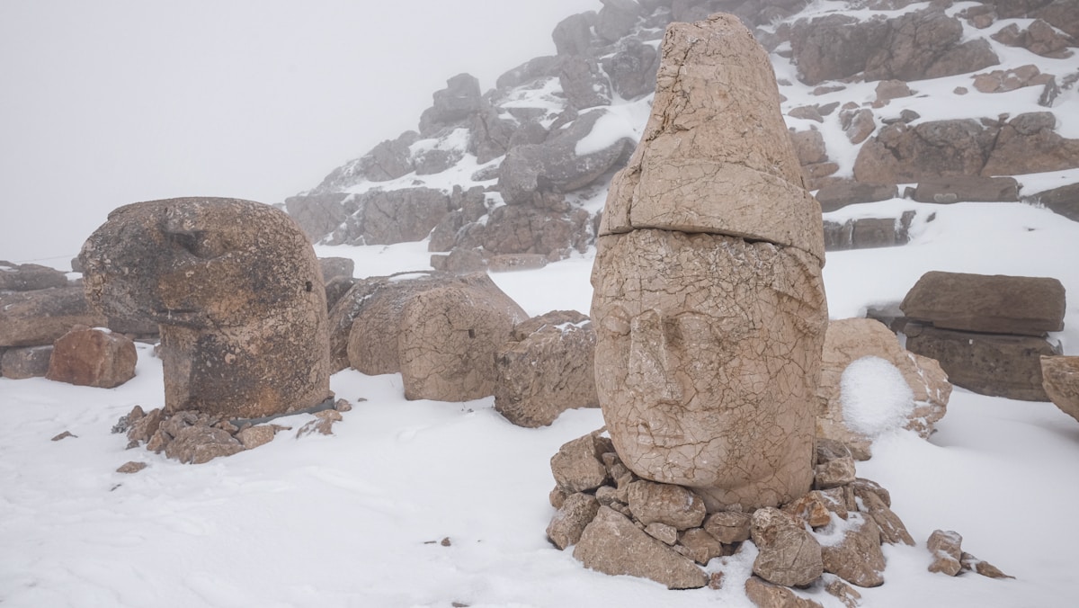Colossal stone heads of gods and kings on the snow-covered summit of Mount Nemrut, Turkey