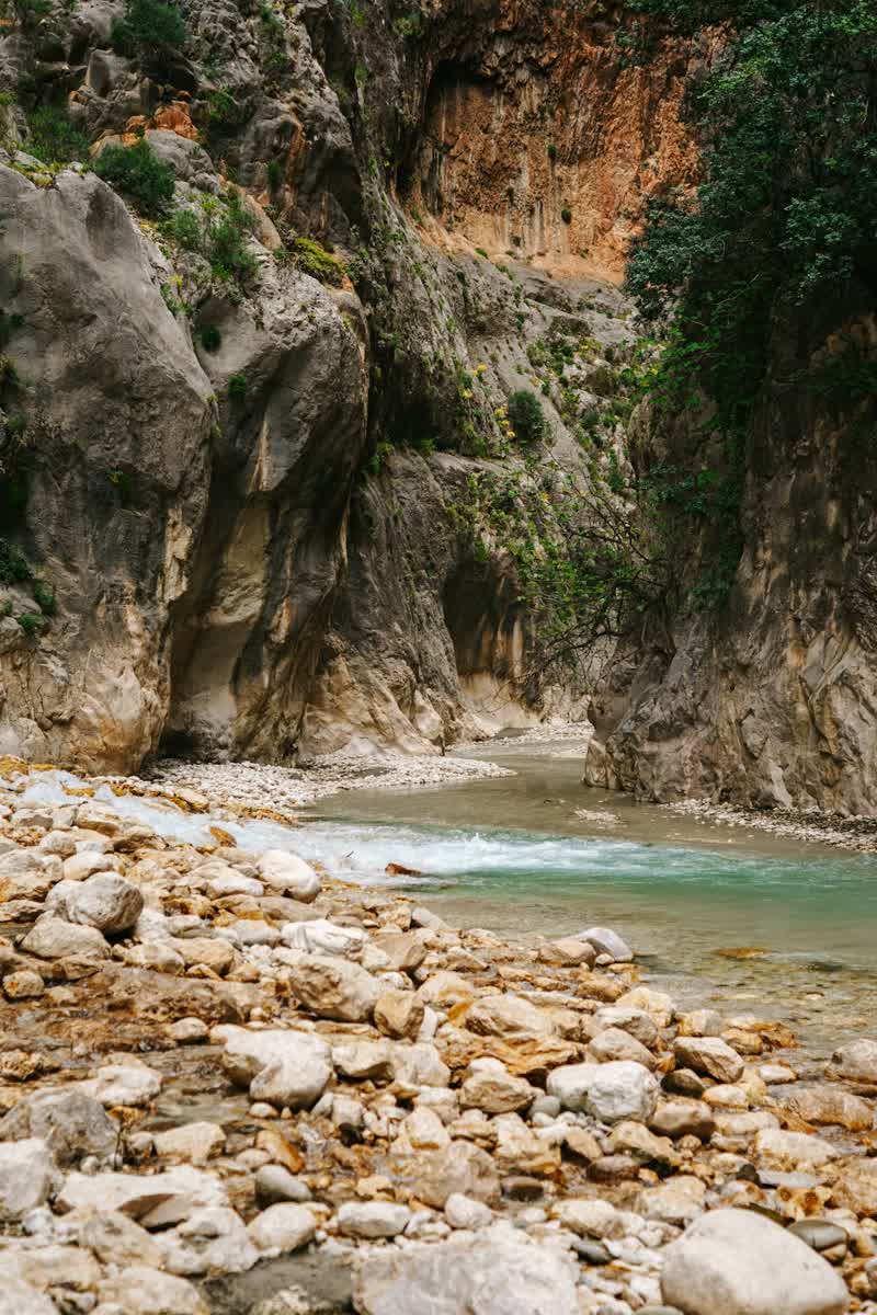 Rocky limestone canyon gorge with clear turquoise water flowing between the cliffs, Fethiye region, Turkey