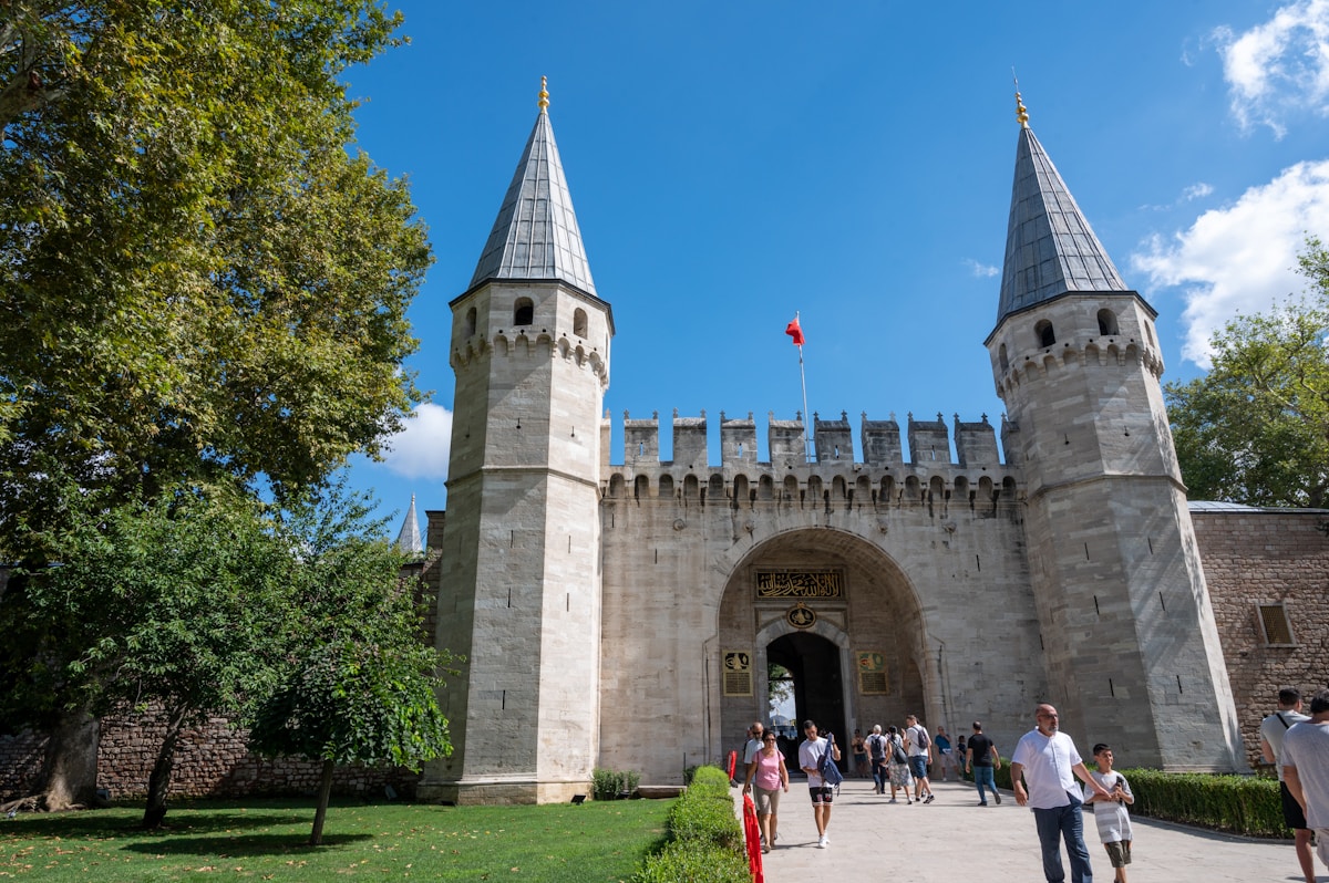 The Gate of Salutation at Topkapi Palace with two towers and visitors walking through, Istanbul, Turkey