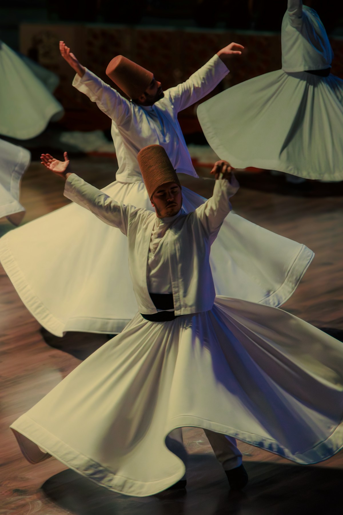 Mevlevi dervishes in white robes and tall brown felt hats performing the Sema ceremony, Turkey