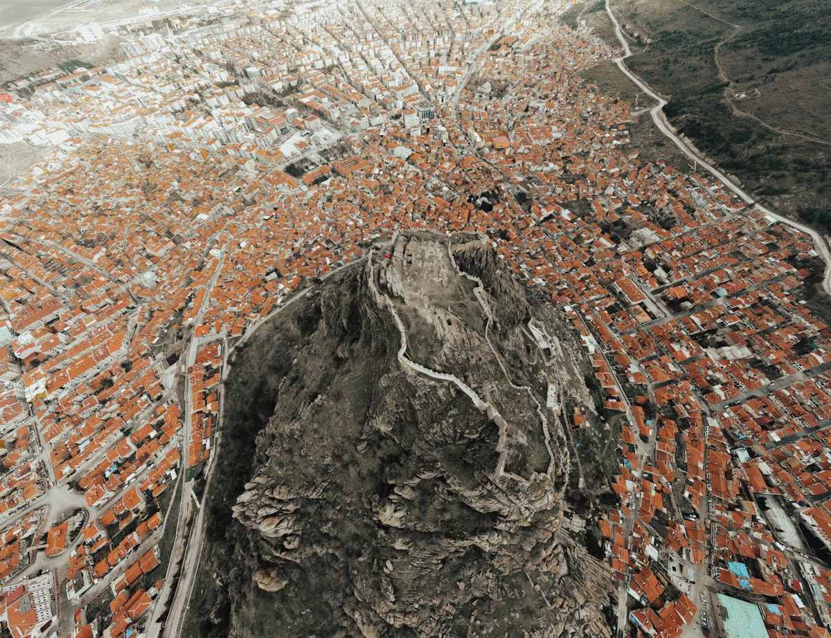 Drone view of Afyonkarahisar Castle above the city's orange roofs