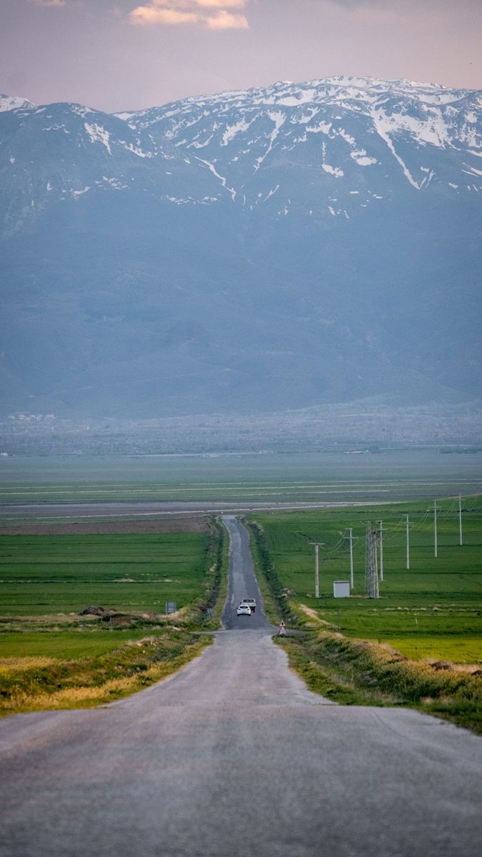 Road through the fields of Sultandagi with snowcapped mountains