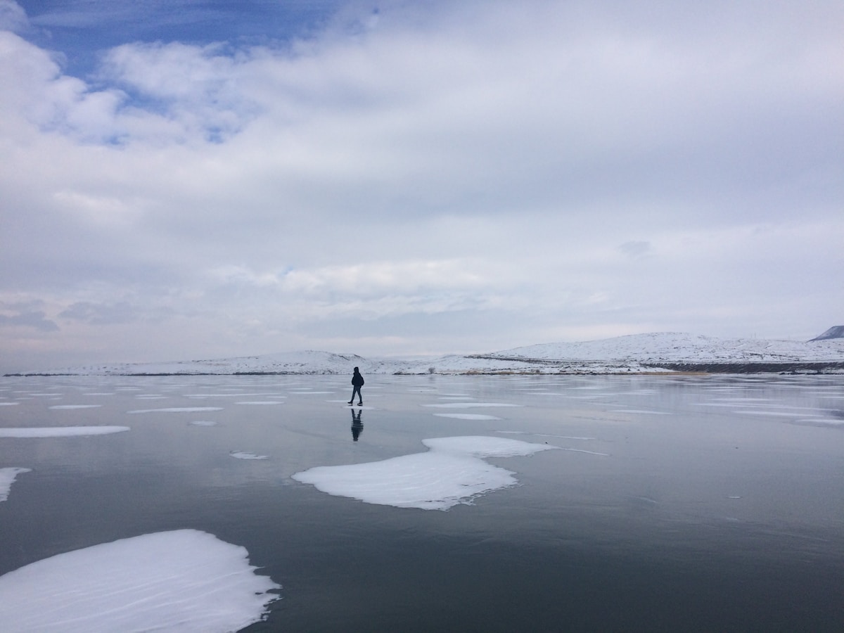 Person silhouette walking on a frozen Lake Çıldır in Kars — eastern Turkey winter landscape