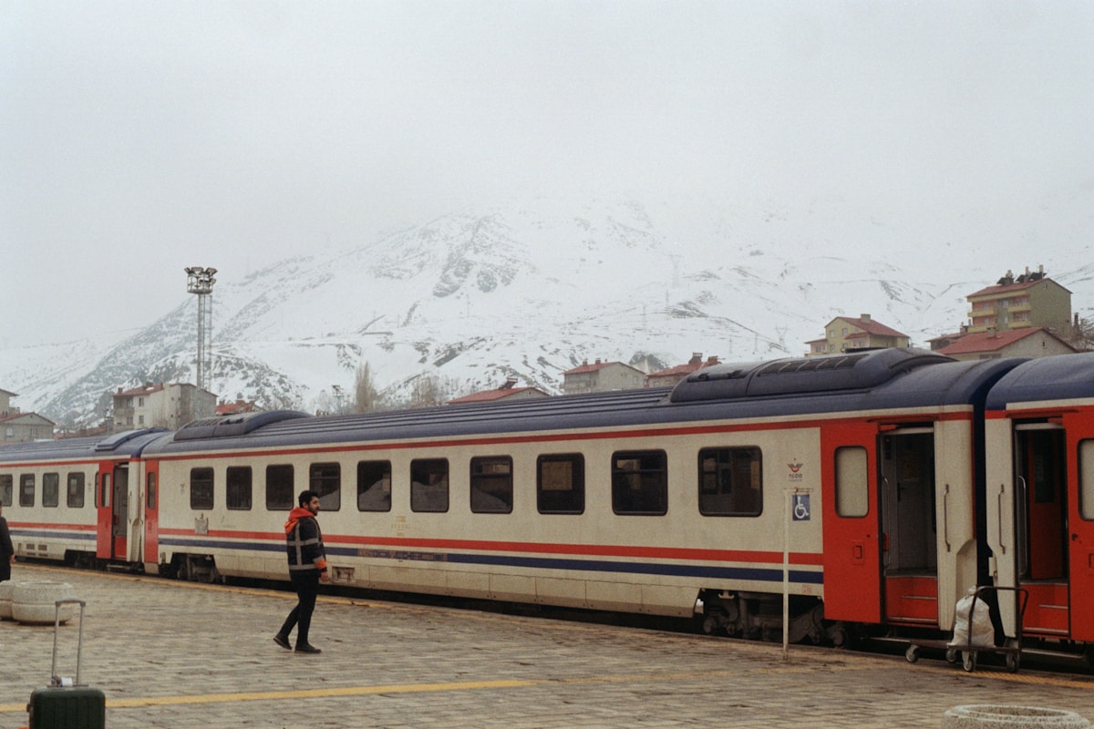 TCDD passenger train at a snowy station in eastern Turkey with mountains in the background