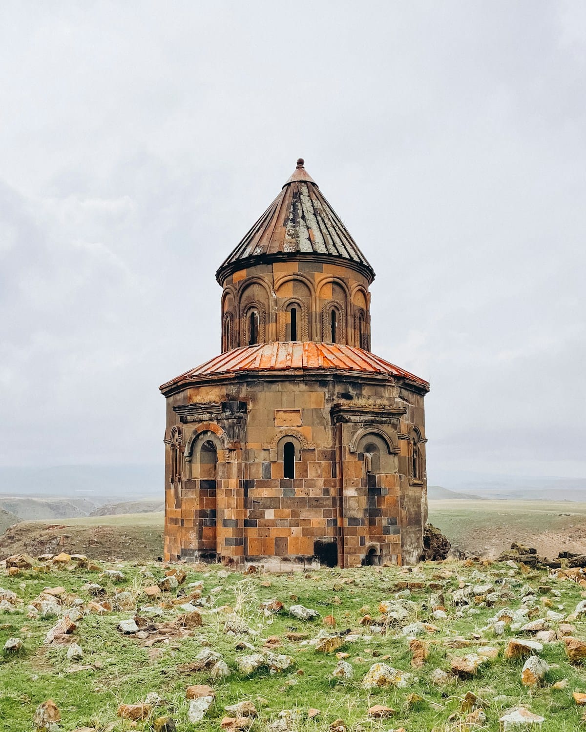 A stone church stands alone on grassy land at the Ani ruins, Kars, eastern Turkey