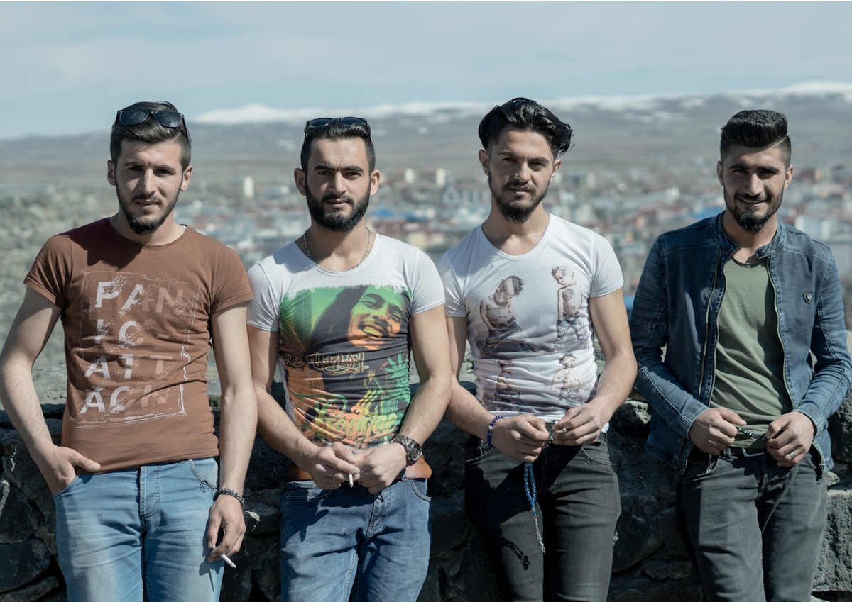 Young men at Kars castle overlook with snow-capped mountains and Kars city in the background, northeastern Turkey