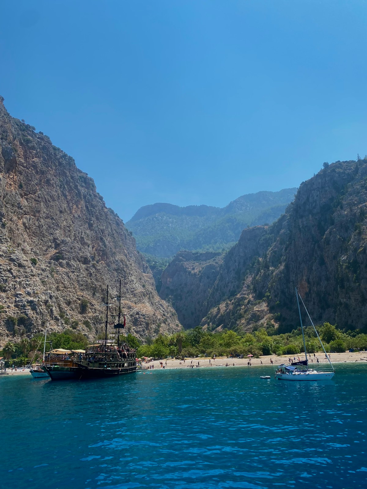 Butterfly Valley (Kelebekler Vadisi) near Fethiye — boats in turquoise bay with dramatic limestone cliffs, Turkey