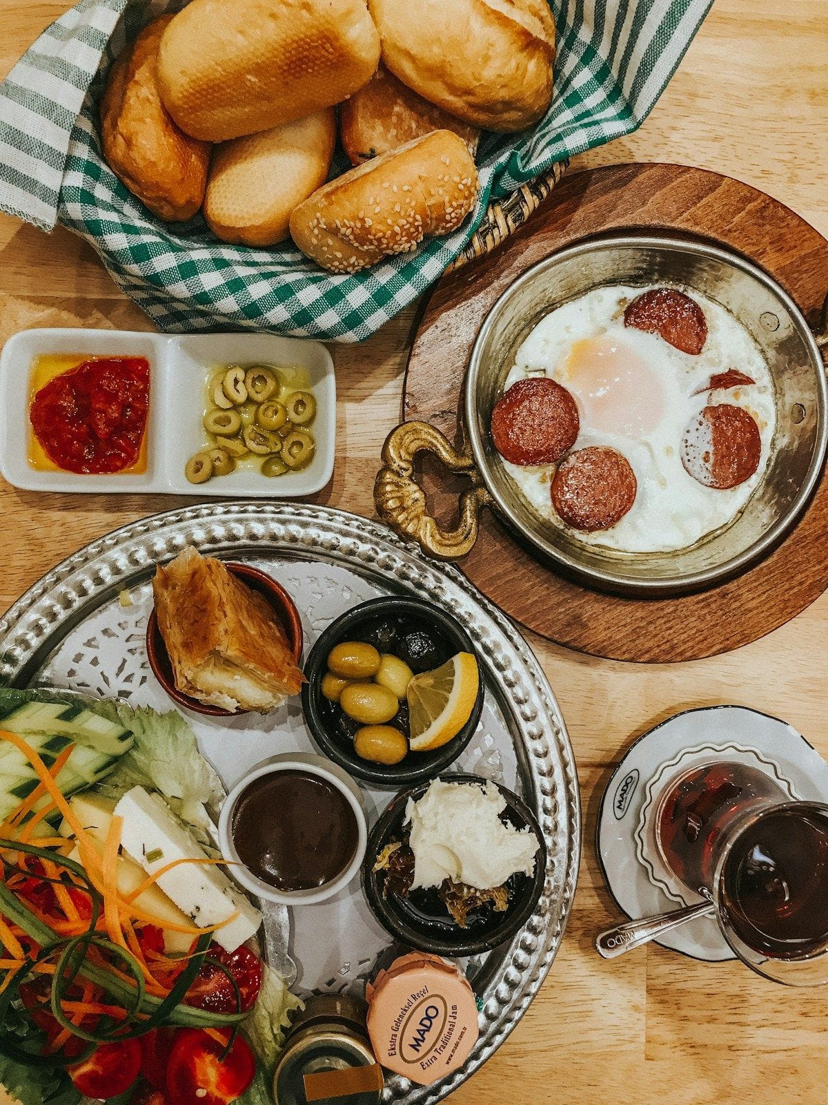 Turkish breakfast spread with simit, cheese, olives, eggs and tea on a wooden table