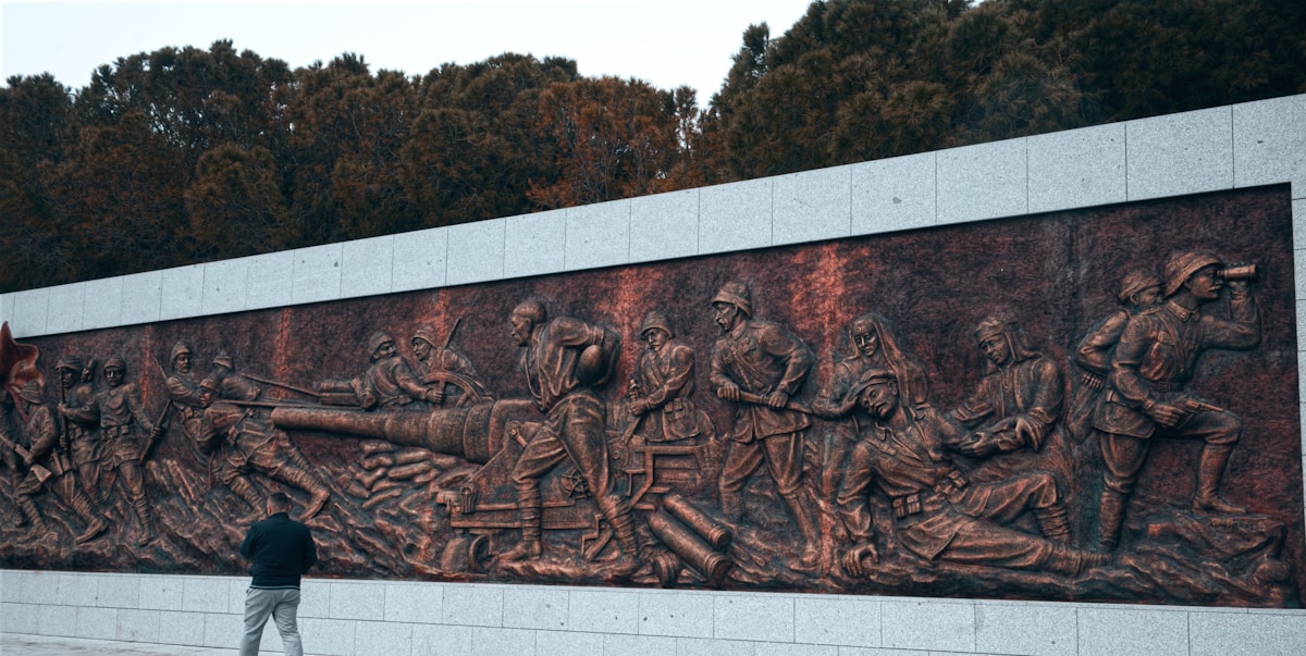 Man stands before a large historical relief sculpture at the Gallipoli memorial, Çanakkale, Turkey