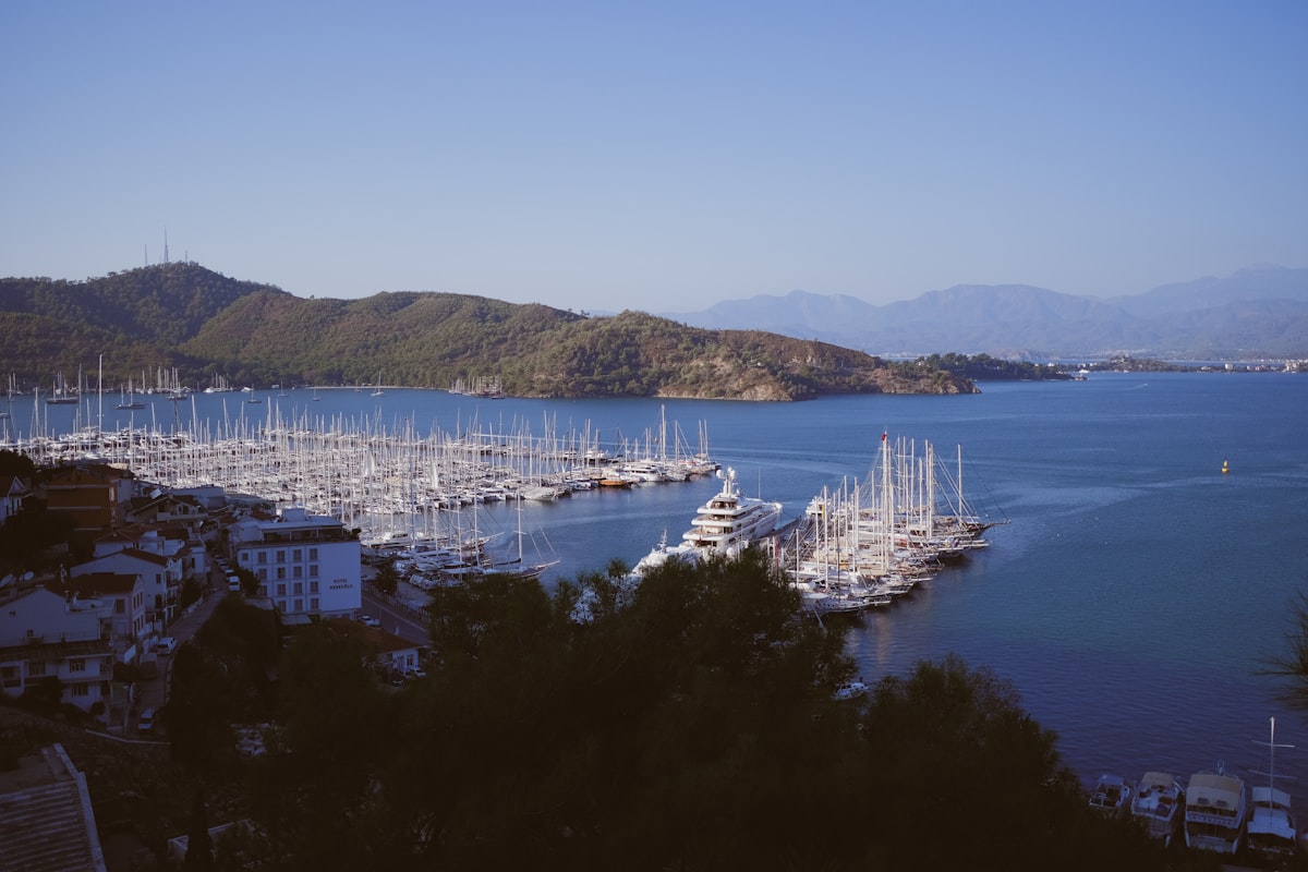 Fethiye marina packed with sailing boats and gulets, pine-covered hills rising behind