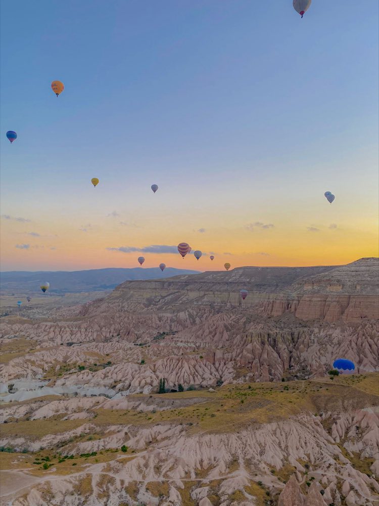 Montgolfières au lever du soleil au-dessus des vallées rosées de Cappadoce