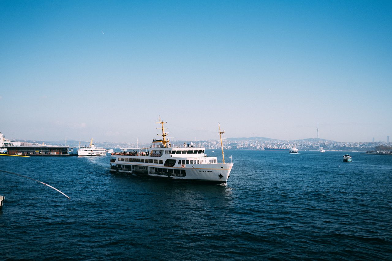 Ferry blanc d'Istanbul traversant le Bosphore devant la silhouette de la ville