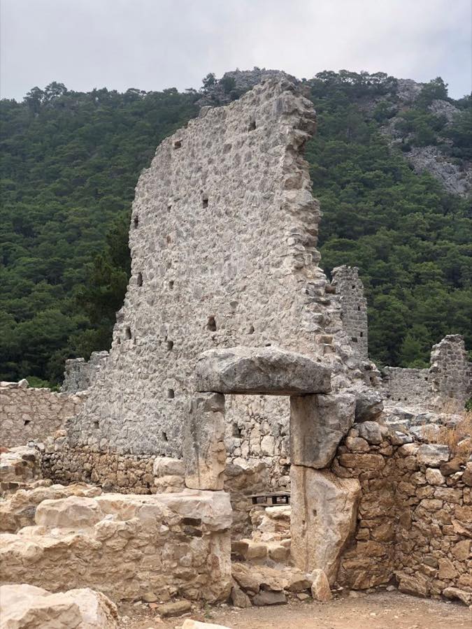 Mur de la cité antique et porte en pierre dans la forêt de pins d'Olympos