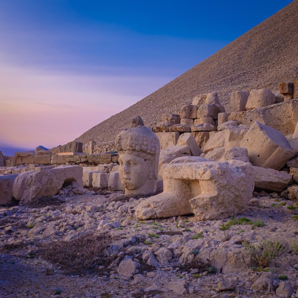 Tête de pierre tombée parmi les blocs de la terrasse du Nemrut dans la lumière de l'aube