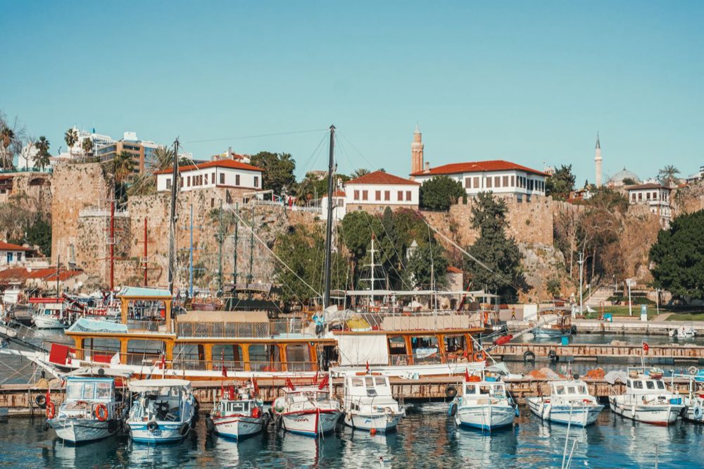 Bateaux dans le vieux port d'Antalya sous les remparts et les maisons aux toits rouges