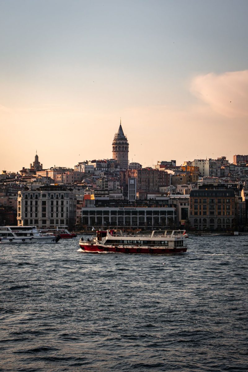 Sunset over Istanbul's Galata Tower with ships on the water