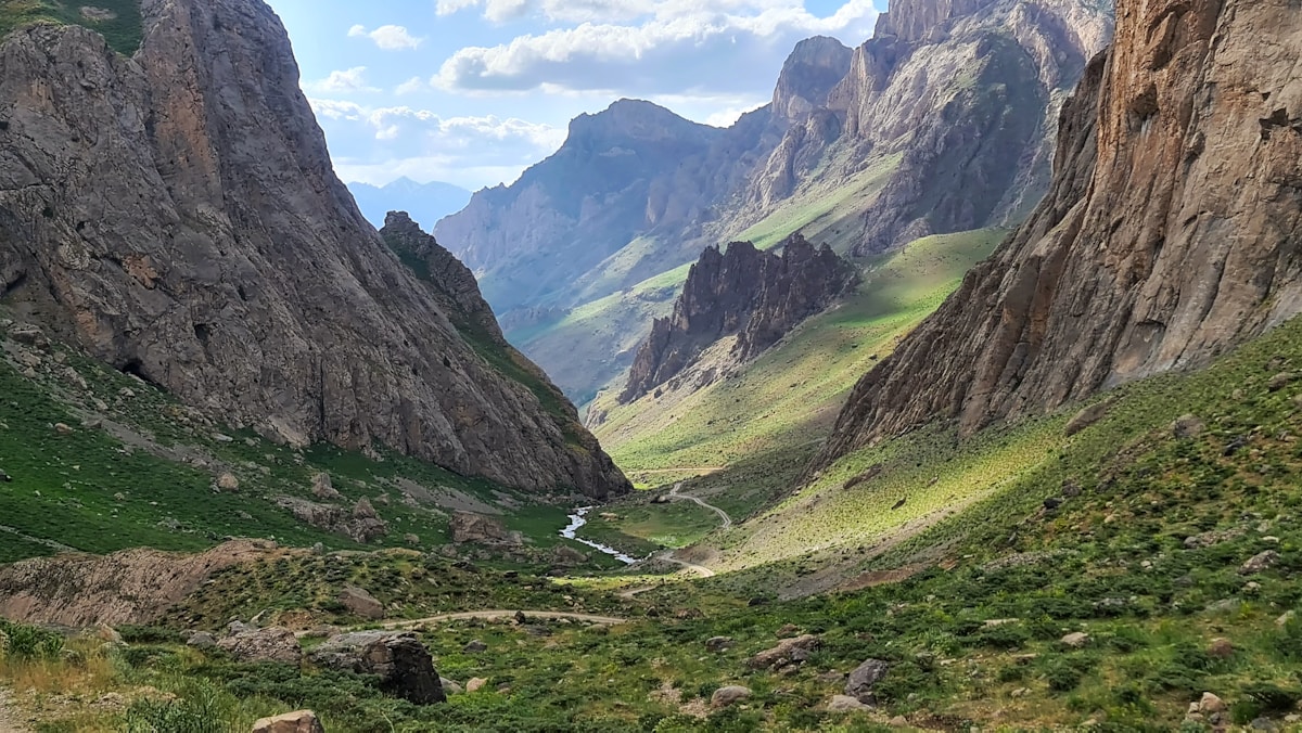 Dramatic rocky mountain valley with a river winding through lush green slopes in eastern Turkey