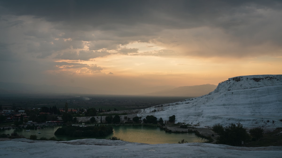 Weiße Travertinterrassen von Pamukkale mit Thermalbecken im Abendsonnenlicht