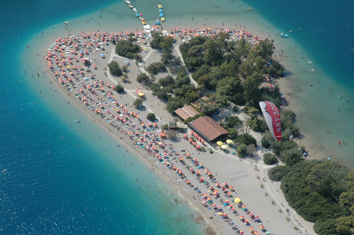 Tandem paraglider in the sky above a green landscape — paragliding near Ölüdeniz, Turkey