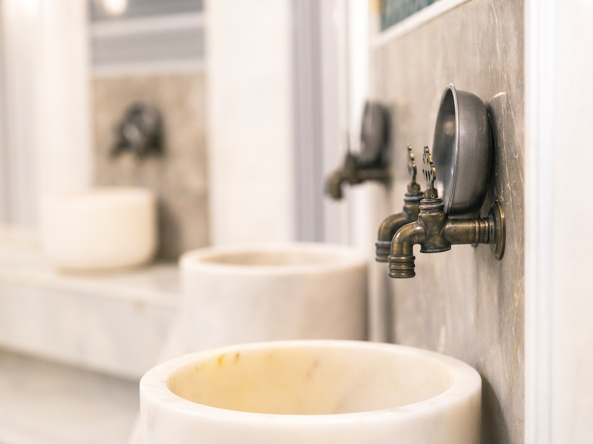 Marble washing basins and brass taps inside a traditional Turkish hammam