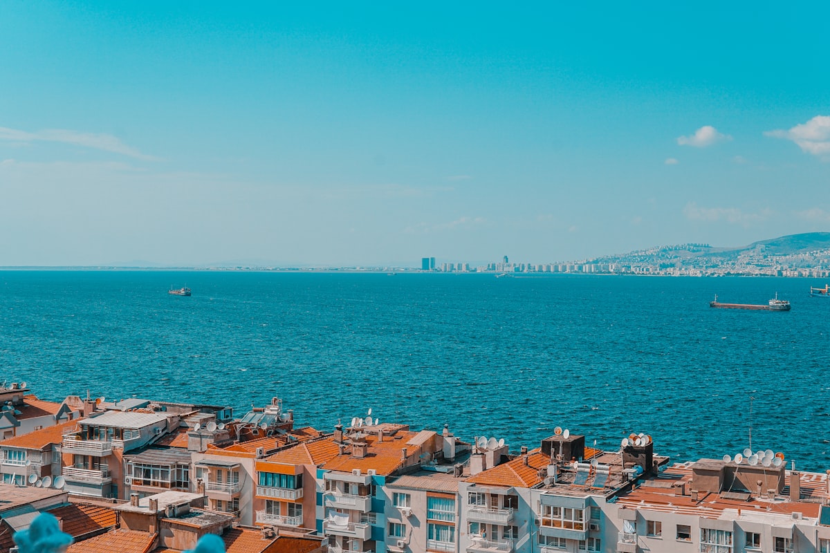 Aerial view of Izmir bay with terracotta rooftops and cargo ships on the turquoise Aegean Sea, Turkey