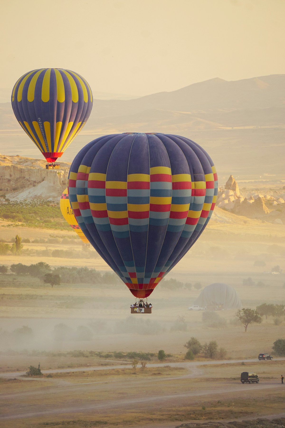 Colorful hot air balloons floating over the valleys and fairy chimneys of Cappadocia, Turkey at sunrise