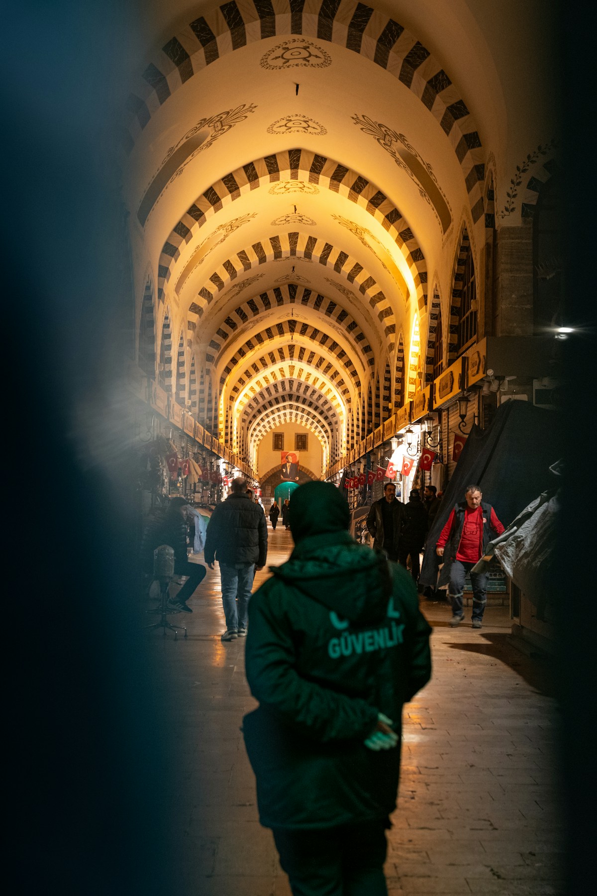 People walking through the ornate arched hallway of the Grand Bazaar in Istanbul, Turkey