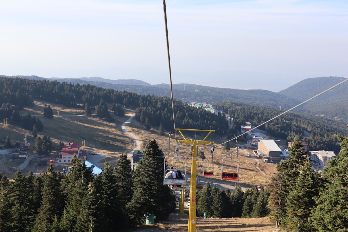 Chairlift rising above the hotel zone at Uludağ ski resort, Bursa, with forested slopes and resort buildings visible below