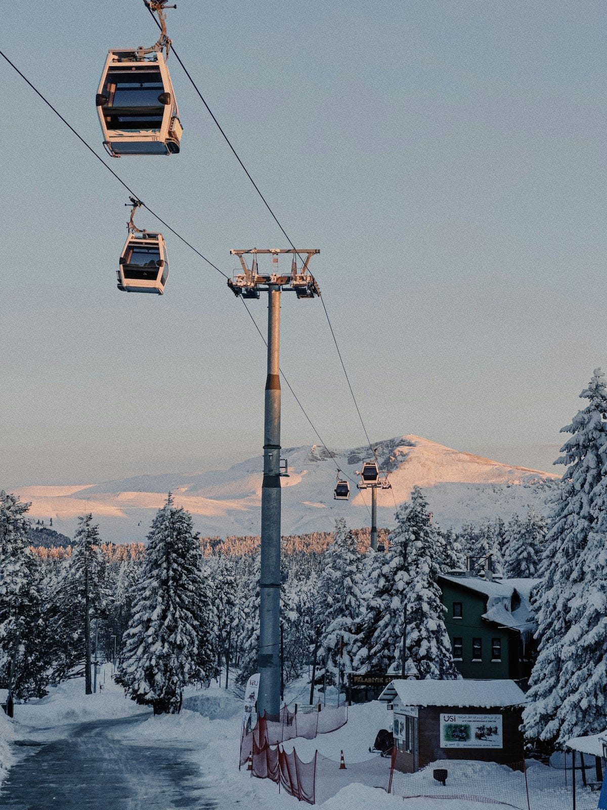 Ski gondola cabins over snow-covered pines and mountain peaks at a Turkish ski resort