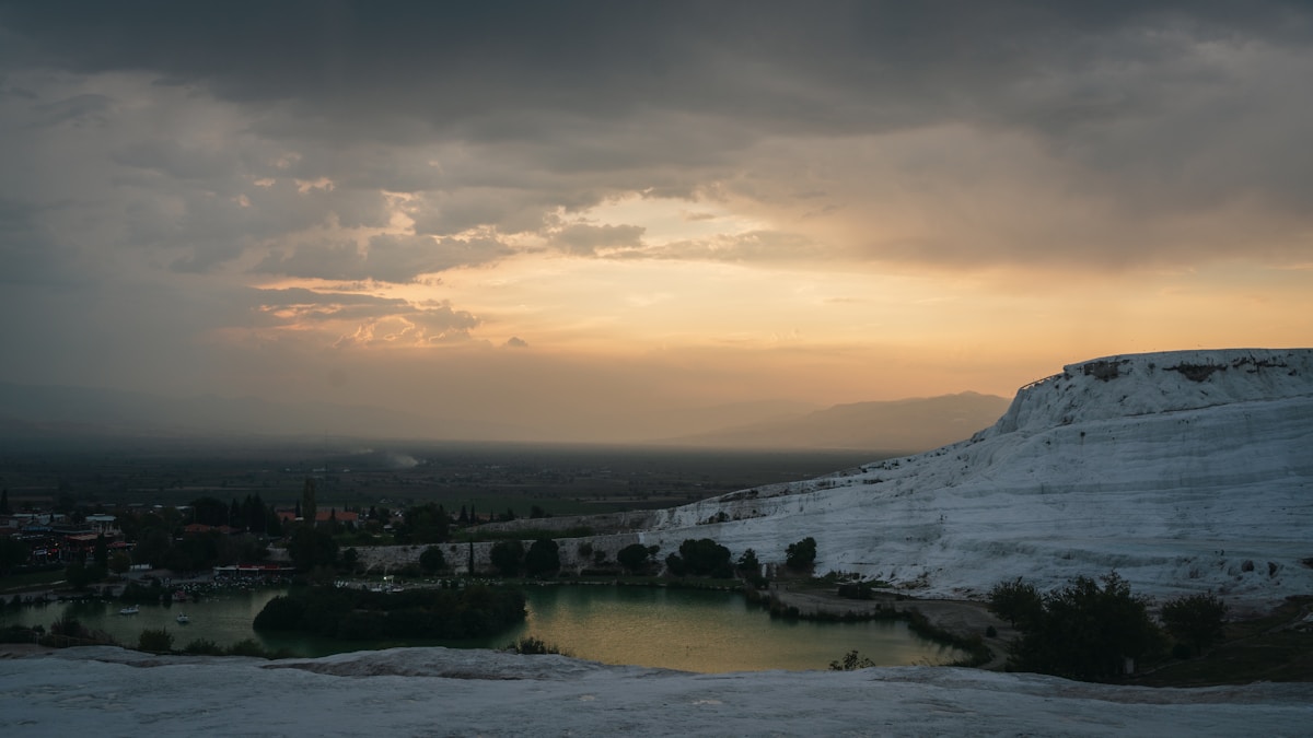 Pamukkale white travertine terraces at sunset overlooking the Denizli valley, Türkiye