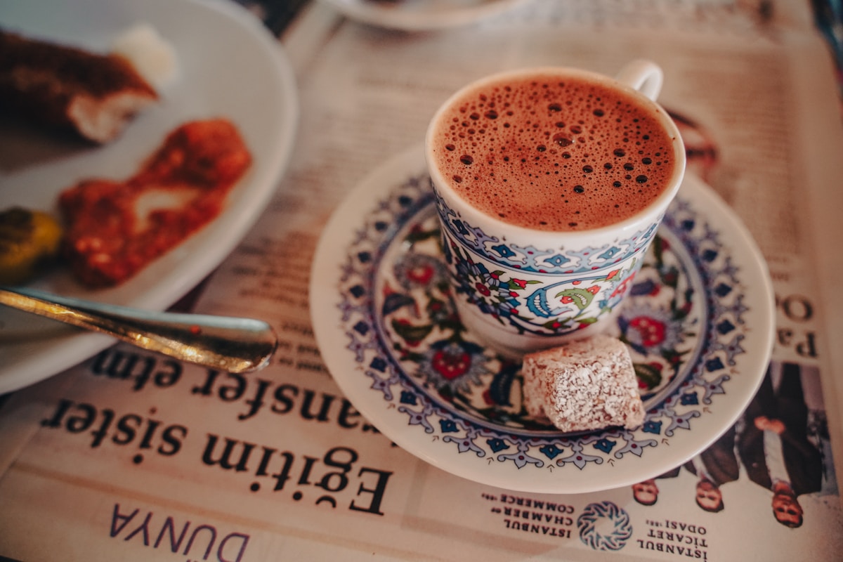 Traditional Turkish coffee in an ornate ceramic cup beside a cube of lokum on a saucer in Istanbul