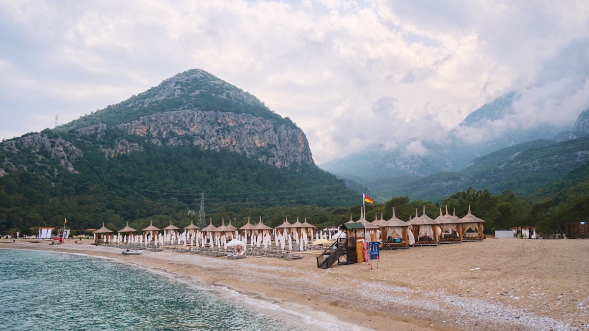 Antalya beach with sun shelters and the Taurus Mountains in the background, Turkish Riviera, Turkey